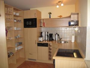 een kleine keuken met houten kasten en een wastafel bij Apartment Müritz Ferienpark Röbel-14 by Interhome in Röbel