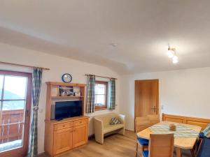 sala de estar con mesa de comedor y TV en Apartment Unterpirchhof by Interhome, en Thumersbach