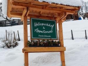 un cartel en la nieve frente a un edificio en Apartment Unterpirchhof by Interhome, en Thumersbach