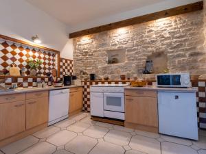 uma cozinha com electrodomésticos brancos e uma parede de pedra em Apartment Belles Pierres by Interhome em Calvisson