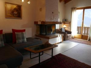 ein Wohnzimmer mit einem Sofa und einem Kamin in der Unterkunft Apartment Chalet Blaugletscher by Interhome in Grindelwald