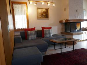 ein Wohnzimmer mit einem Sofa und einem Tisch in der Unterkunft Apartment Chalet Blaugletscher by Interhome in Grindelwald