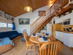 a kitchen and living room with a wooden table and chairs at Holiday Home Golf Loisirs-1 by Interhome in Lacanau-Océan