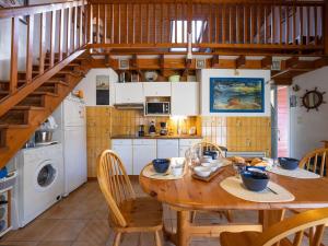 kuchnia z drewnianym stołem i drewnianymi schodami w obiekcie Holiday Home Golf Loisirs-1 by Interhome w mieście Lacanau-Océan
