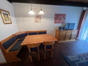 a dining room with a wooden table and chairs at Holiday Home Koralle-1 by Interhome in Norddeich