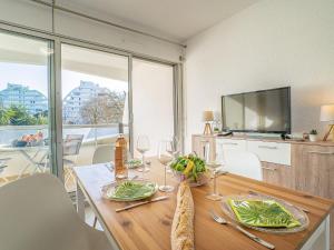 a dining room with a table and a television at Studio du Parc I by Interhome in La Grande Motte