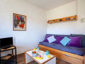 una sala de estar con un sofá y una mesa en Apartment Lunik Orion-22 by Interhome, en Le Corbier