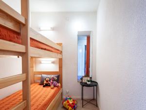 two dolls sitting on a bunk bed in a room at Apartment Lunik Orion-22 by Interhome in Le Corbier