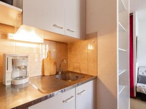 a kitchen with a sink and a microwave at Apartment Les Mousquetons-19 by Interhome in La Toussuire