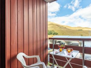 a patio with a table and chairs on a deck at Apartment Les Mousquetons-19 by Interhome in La Toussuire