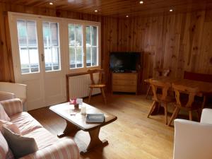 ein Wohnzimmer mit einem Sofa und einem Tisch in der Unterkunft Apartment Chalet Anna by Interhome in Grindelwald