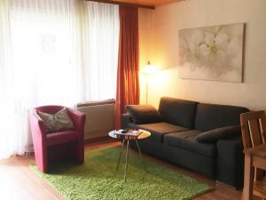 ein Wohnzimmer mit einem Sofa und einem Stuhl in der Unterkunft Apartment Blumenweg 8 by Interhome in Engelberg