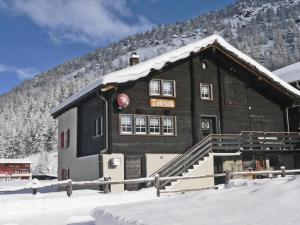 a building with a snow covered roof in the snow at Apartment Talblick by Interhome in Saas-Grund