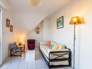 een woonkamer met een bank en een stoel bij Studio Appartement Aillerie by Interhome in Dinard
