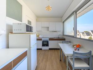 a kitchen with white appliances and a table with chairs at Apartment Kérabus-1 by Interhome in Quiberon