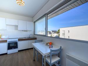 a kitchen with a table and a large window at Apartment Kérabus-1 by Interhome in Quiberon