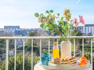 a table with breakfast foods and a vase of flowers at Apartment Kérabus-1 by Interhome in Quiberon