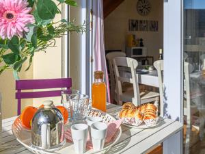 Una mesa con platos de comida y un jarrón de flores. en Apartment Les Villas de Kermaria by Interhome, en Kervoz