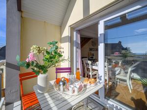 a table on a balcony with a vase of flowers at Apartment Les Villas de Kermaria by Interhome in Kervoz