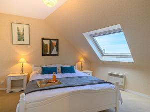 a bedroom with a large bed with a skylight at Apartment Les Villas de Kermaria by Interhome in Kervoz