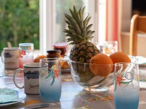 uma mesa com ananás, laranjas e chávenas em Holiday Home Les Dunes-1 by Interhome em Quiberon