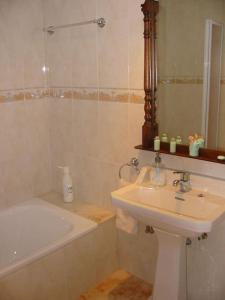 a bathroom with a sink and a bath tub at Las Caldas de Boñar Casa alquiler completo in Boñar