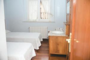 Las Caldas de Boñar Casa alquiler completo في بونيار: غرفة بيضاء بسريرين ومغسلة