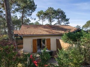 ラカノー・オセアンにあるHoliday Home Jardins de la Pinède-9 by Interhomeの赤屋根の小さな白い家