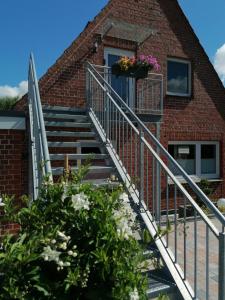 a set of stairs leading up to a brick building with flowers at May Home in Schashagen