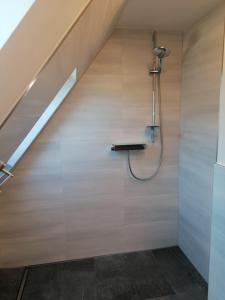 a bathroom with a shower under a stair case at May Home in Schashagen