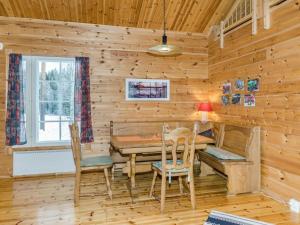 a dining room with a table and chairs in a log cabin at Holiday Home Pihlajapelto by Interhome in Ahmovaara