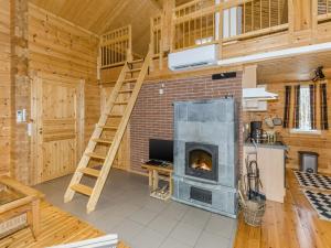 a living room with a fireplace in a log cabin at Holiday Home Pihlajapelto by Interhome in Ahmovaara