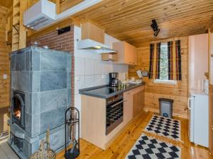 a kitchen with a fireplace in a wooden house at Holiday Home Pihlajapelto by Interhome in Ahmovaara +15 photos
