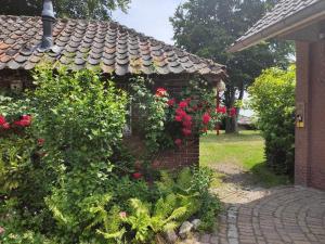 einen Garten mit roten Rosen auf einem Backsteingebäude in der Unterkunft Bergerhof de Stal in Sevenum