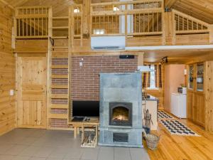 a fireplace in a large room with wooden walls at Holiday Home Pihlajapelto by Interhome in Ahmovaara