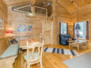 a log cabin living room with a table and chairs at Holiday Home Pihlajapelto by Interhome in Ahmovaara