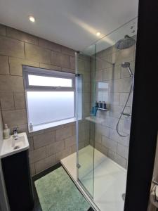 a bathroom with a shower with a glass door at Wishbone House in Bridlington