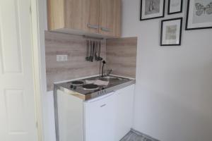 a kitchen with a sink and a stove top oven at Apartments am Lindengraben in Emden