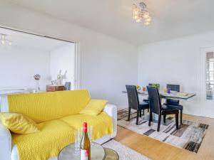 ein Wohnzimmer mit einem gelben Sofa und einem Tisch in der Unterkunft Apartment Océana by Interhome in Biarritz