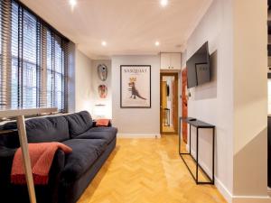 a living room with a couch and a tv at Pass the Keys Stylish 1 bedroom flat by Kings Road in Chelseag in London