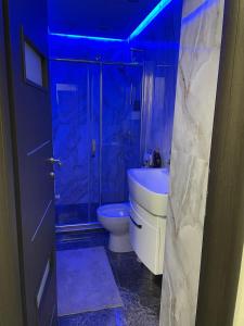 baño con aseo y ducha con luces azules en Amira 2, en Târgovişte