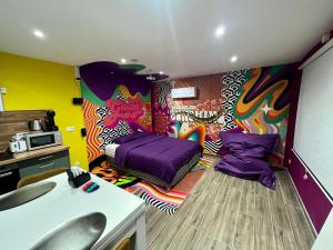 Zimmer mit einem Bett und einem Wandgemälde in der Unterkunft Capsule Groovy-Jacuzzi-Sauna-Billard-Netflix- Nintendo Switch & Jeux in Mons