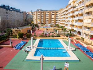 an outdoor swimming pool with chairs and a building at Apartment Apolo VII-5 by Interhome in Calpe