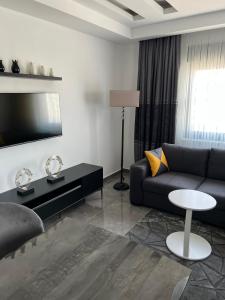 a living room with a couch and a tv at PERLI TOWERS in Alanya