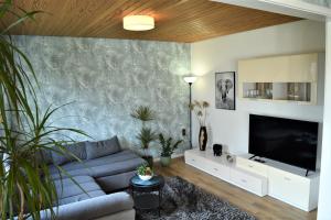 a living room with a couch and a flat screen tv at Ferienhaus Heideglück in Bad Fallingbostel