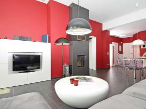 ein Wohnzimmer mit roten Wänden und einem weißen Tisch in der Unterkunft Villa "To Hus" F590 - Appartement 01 im EG mit Kamin und Terrasse in Ostseebad Sellin