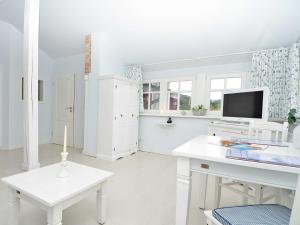 a white living room with a desk and a tv at Villa "To Hus" in Sellin - Appartement 06 im DG mit Balkon in Ostseebad Sellin