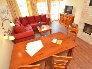 a living room with a red couch and a table at Villa "To Hus" in Sellin - WG 02 mit Kamin und Balkon in Ostseebad Sellin