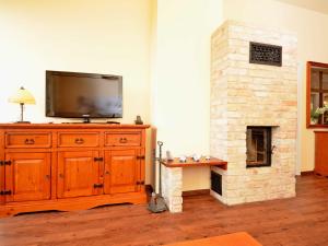 a living room with a television and a fireplace at Villa "To Hus" in Sellin - WG 02 mit Kamin und Balkon in Ostseebad Sellin