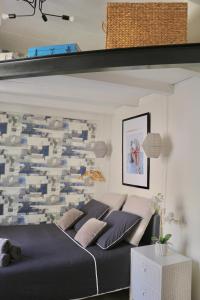 um quarto com uma cama grande e almofadas azuis em Sacré coeur de ville em Lunel